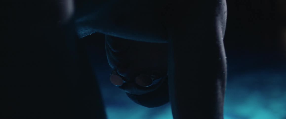 A swimmer near a pool dripping water
