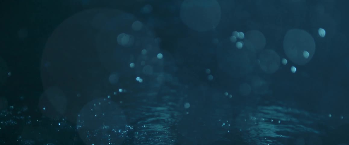 Bubbles form beneath the surface of a blue liquid