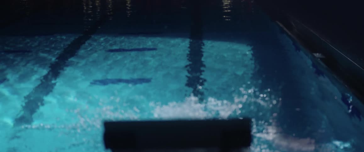 Man dives into a pool and swims