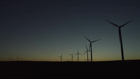 Wind turbines run as the sun sets