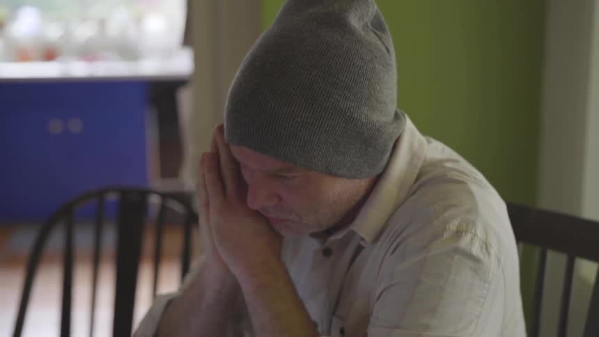 Man Working On Computer At Kitchen Table
