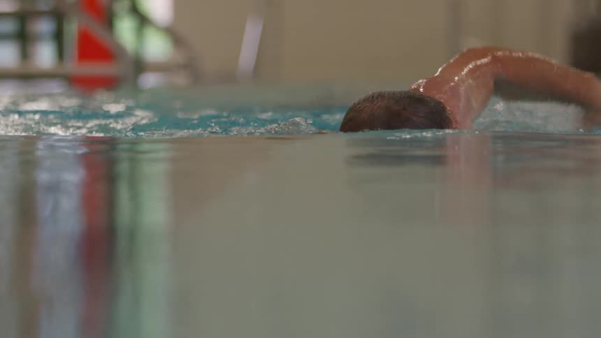 Man Swimming Laps In Indoor Pool