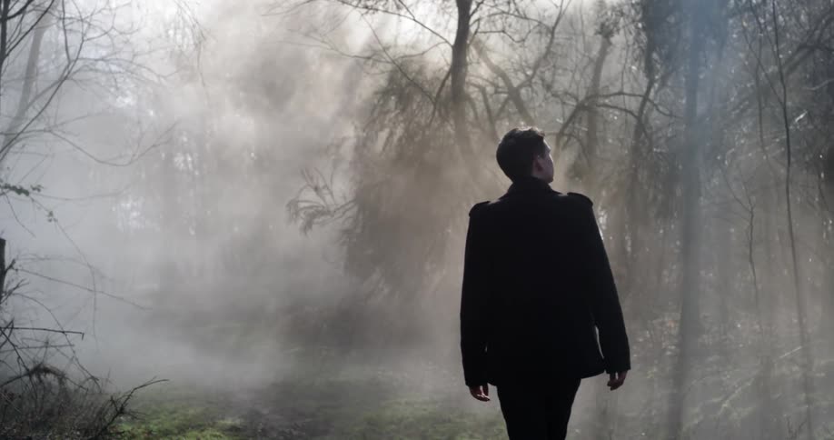 A man walking through foggy woods
