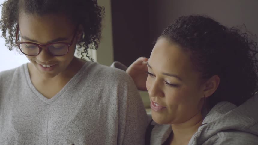 Mom And Daughter Talk In A Living Room