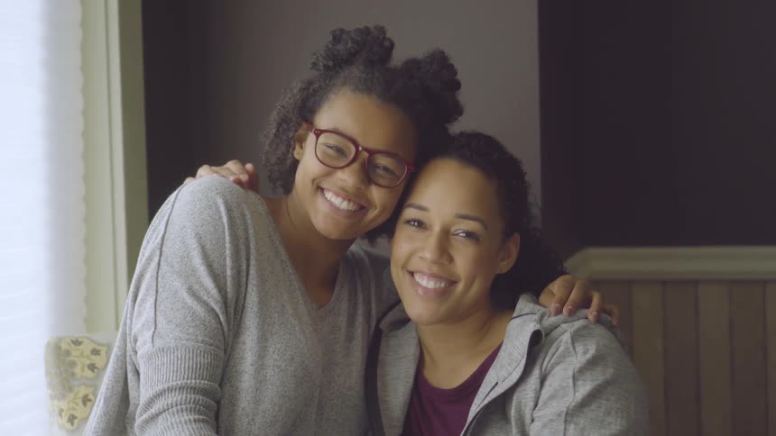 Mom And Daughter Talk In A Living Room