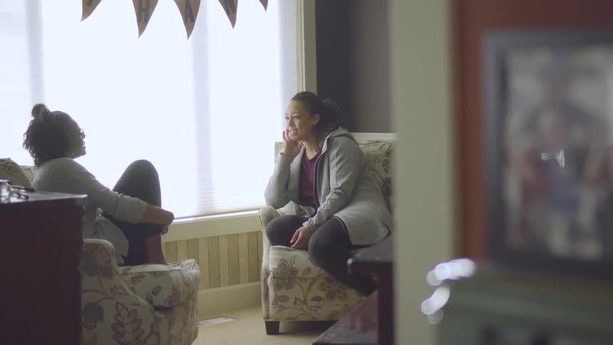 Mom And Daughter Talk In A Living Room