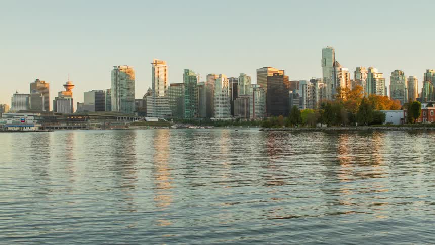Timelapse of a river and city backdrop during the daytime as it fades to night