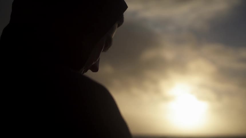 Person walking along the shore as the sunsets