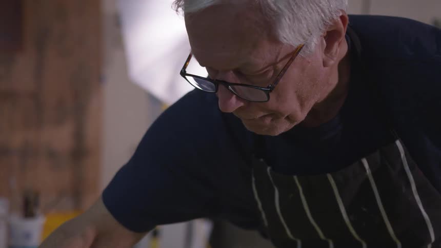 Older Man Painting In Studio
