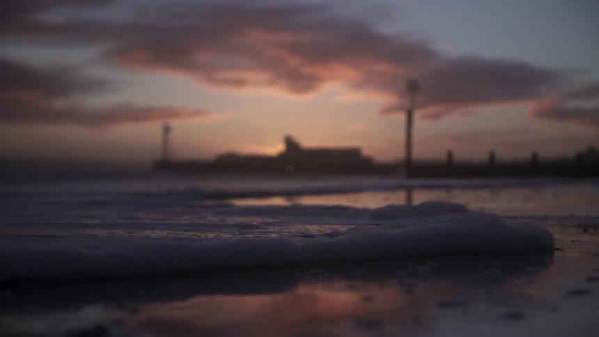 Foamy waves coming ashore at sunset
