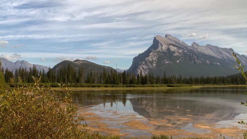Time lapse of a lake with mountains in the distance and heavy clouds