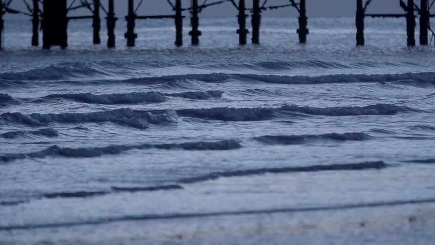 Waves ripple and flow into the coast on the beach