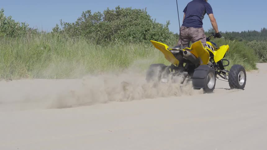 People Riding Four Wheelers In The Sand