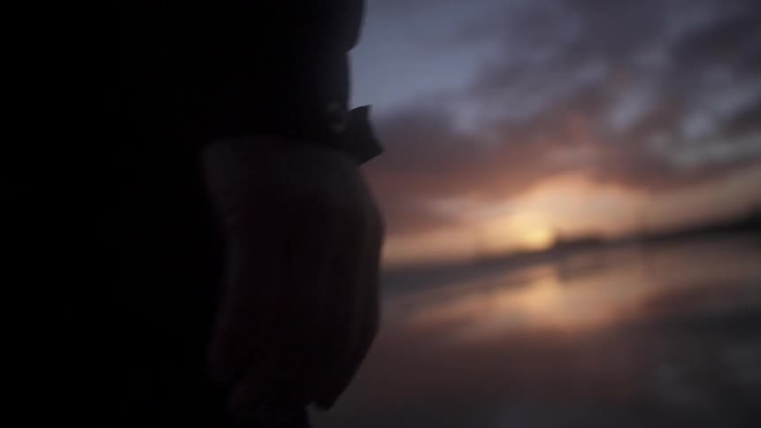 A person walking towards the sunset