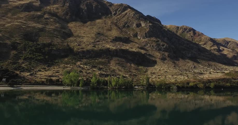 Lake meets a steep mountain on a sunny day