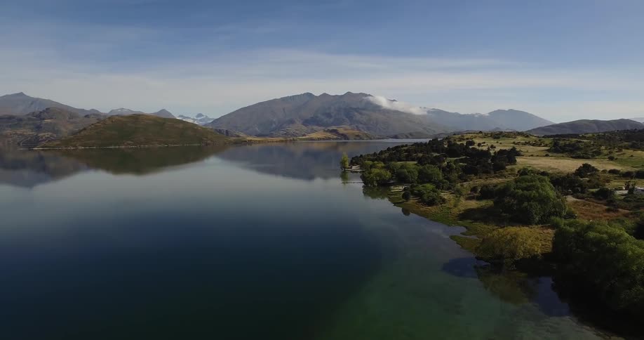 A mountain lake reflects the land and the blue sky above