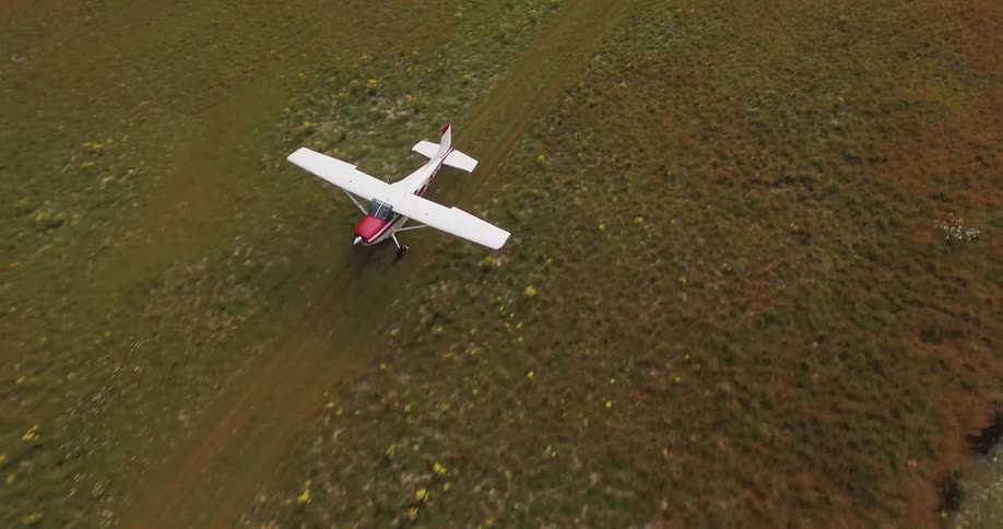 A white and red plane takes off from a field