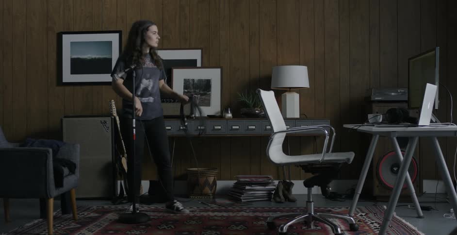 A woman plugs an electrical cord into a standing mike