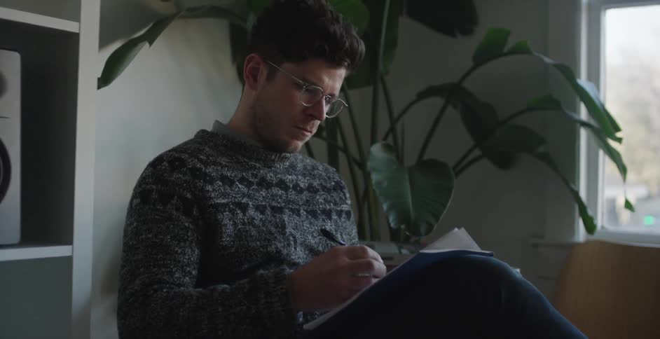 Man writing on a stack of papers