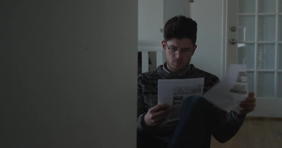 A man writing on a stack of papers