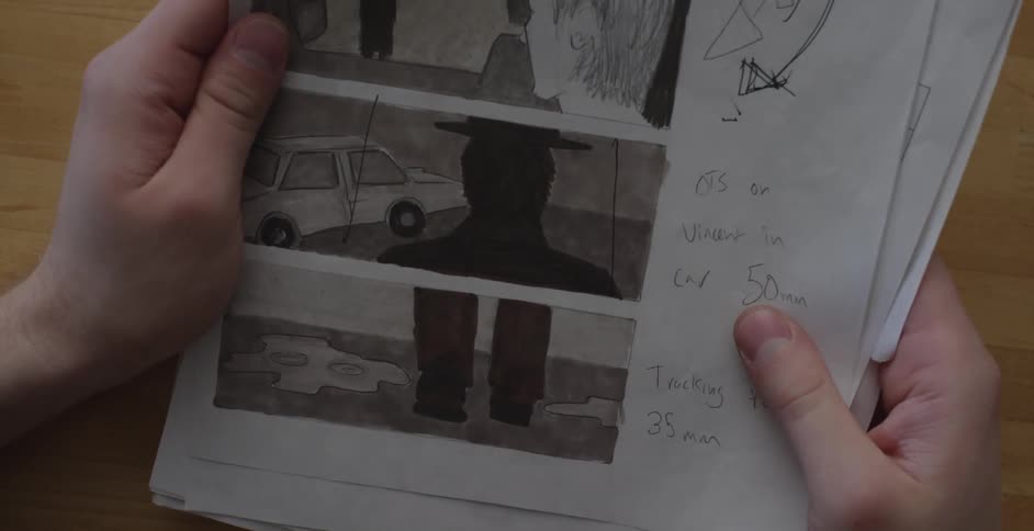 A person flipping through pages of scene sketches