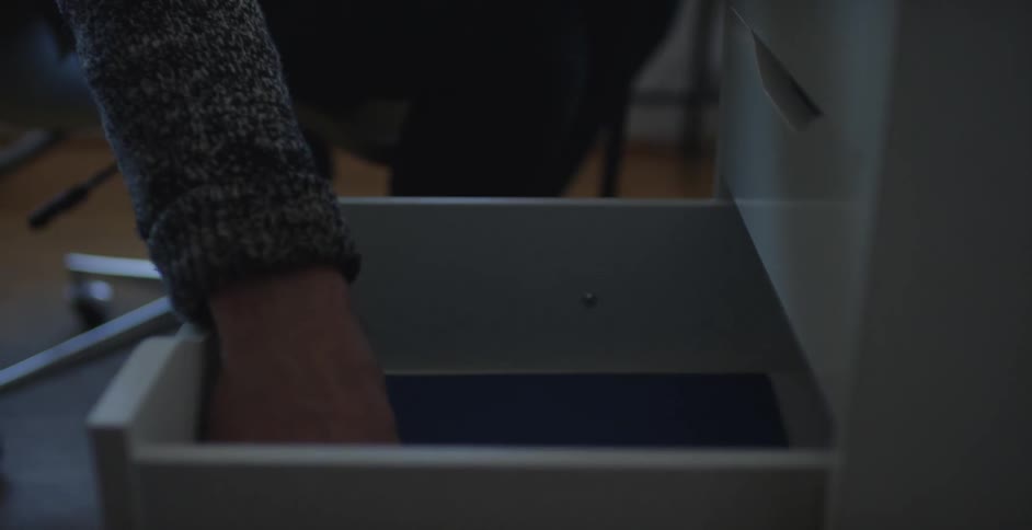Man opening a drawer of a filing cabinet