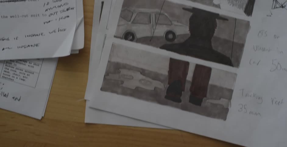 Sheets of paper on a tabletop with scripting notes and storyboard drawings