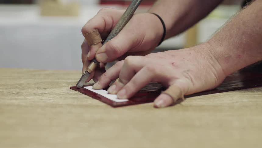 Close up on shaking hands cutting red glass