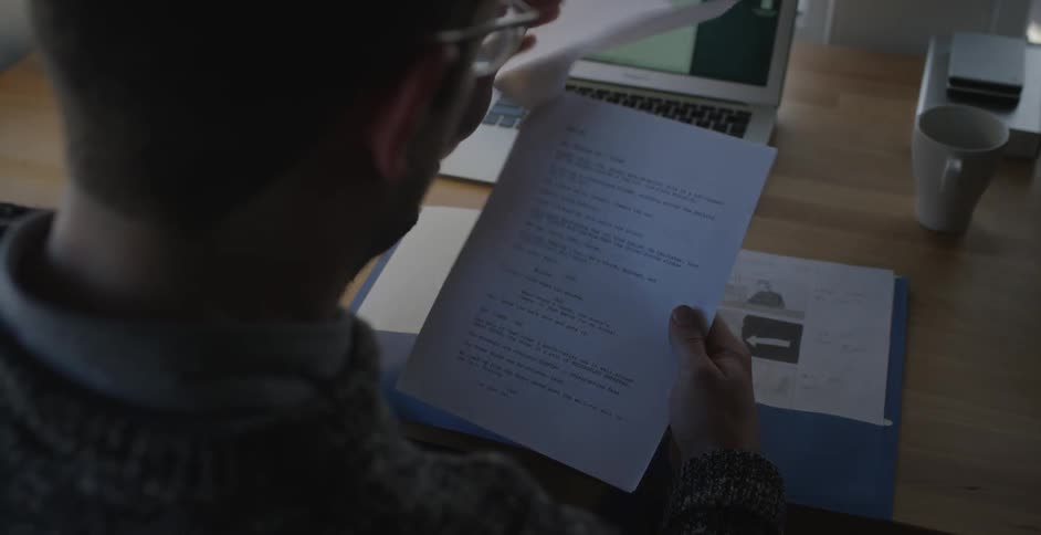A man looking through papers at a desk