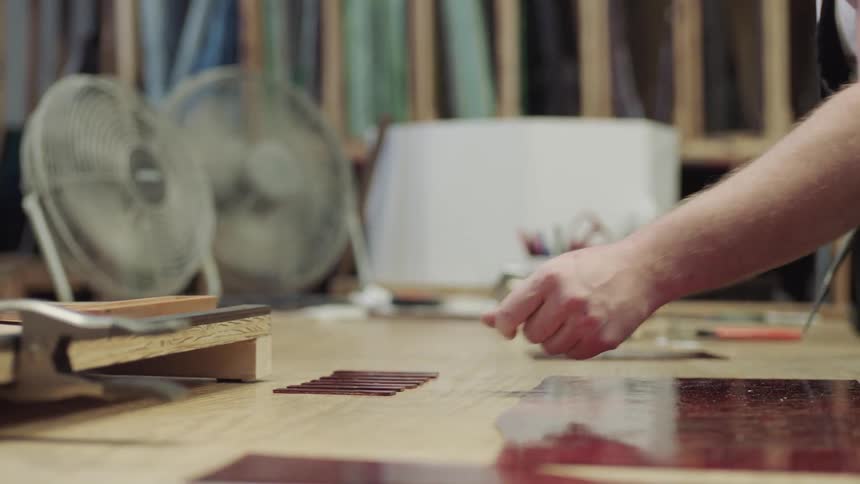 Artist places red glass on work table