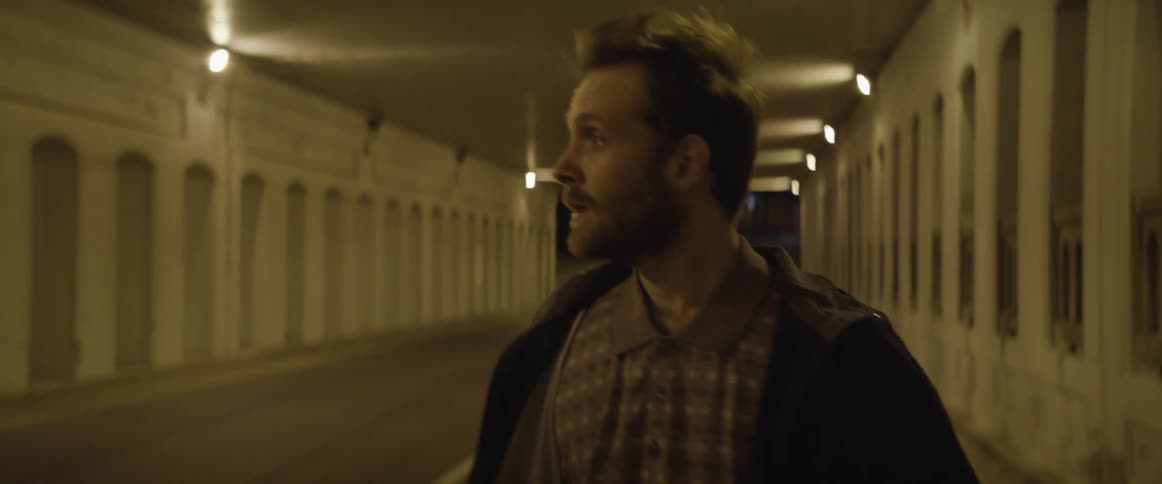 Man walks through a city tunnel at night