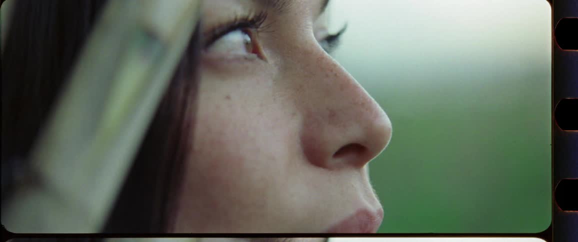 Closeup of a woman with brown eyes with bamboo in the foreground