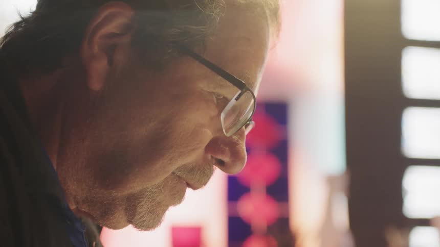 Older man wearing glasses with sunlight behind him