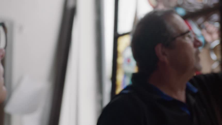Man and woman looking at painted glass