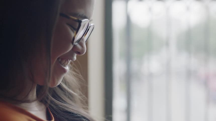 Young adult laughing at image on phone