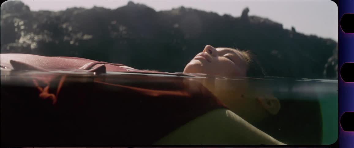 Woman floating in the ocean with her eyes closed