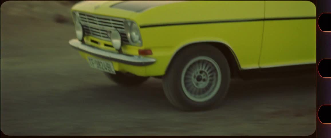 Closeup of yellow car driving through dusty desert scenery
