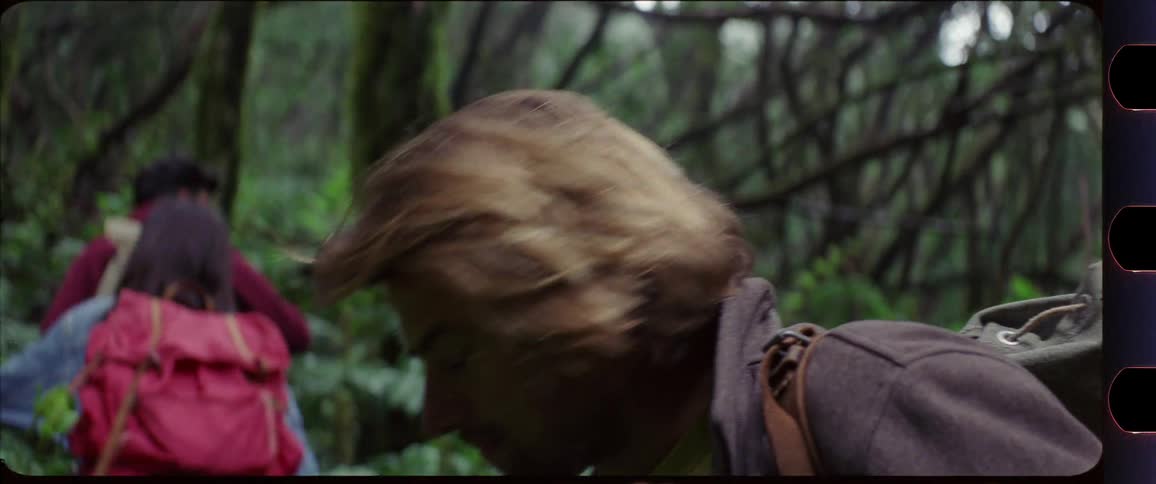 Woman turning around motivating a man while hiking through the forest