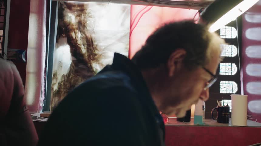 Man sitting in red room looking at desk