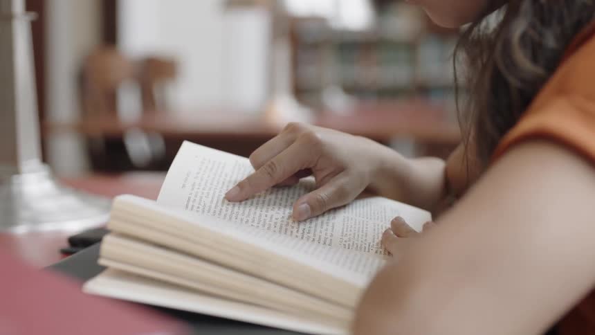 Asian woman looking at book