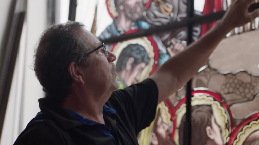 Man pointing at stain glass artwork