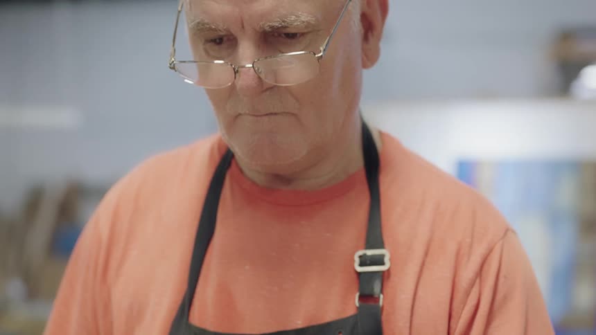Man wearing orange shirt looking down