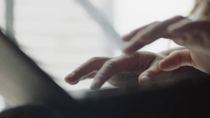 Hand moving over laptop to type