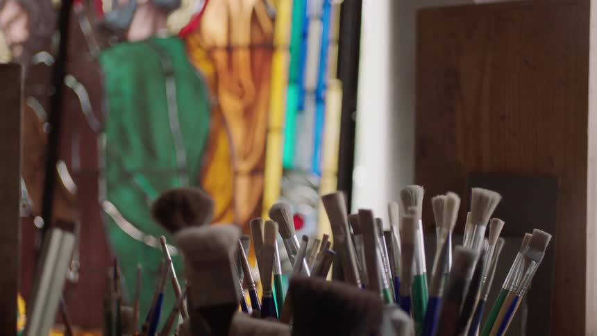 Stain glass artwork with a collection of paint brushes