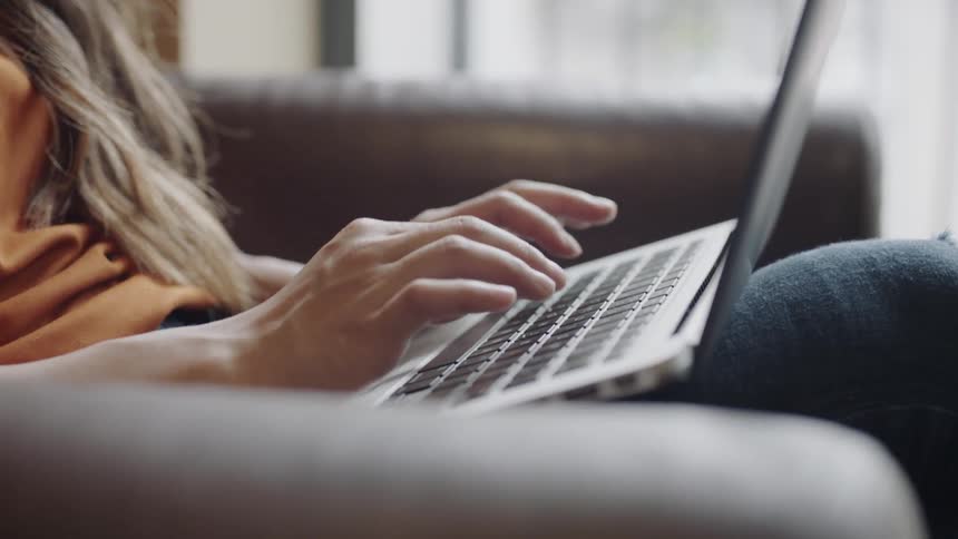 Student sticking out tongue as she types on computer