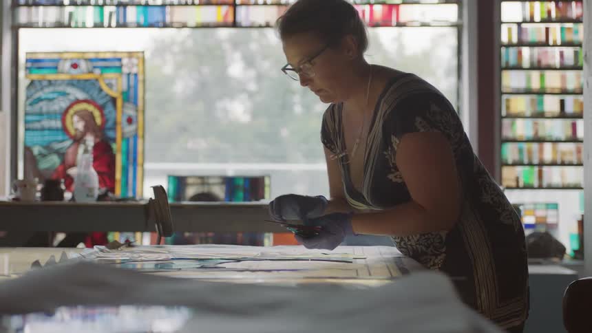 Artist reaching across table to place down pieces