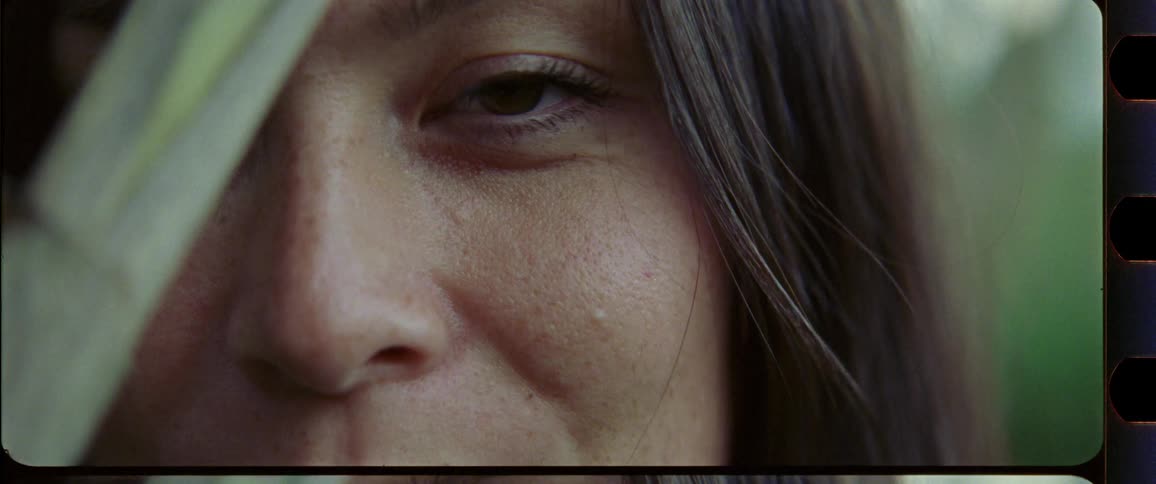 Closeup of a woman with brown eyes with bamboo in the foreground