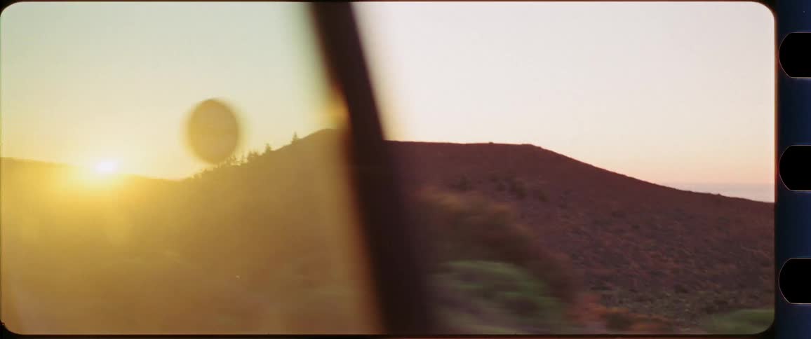 Mountain desert region shot out of a driving car at sunset