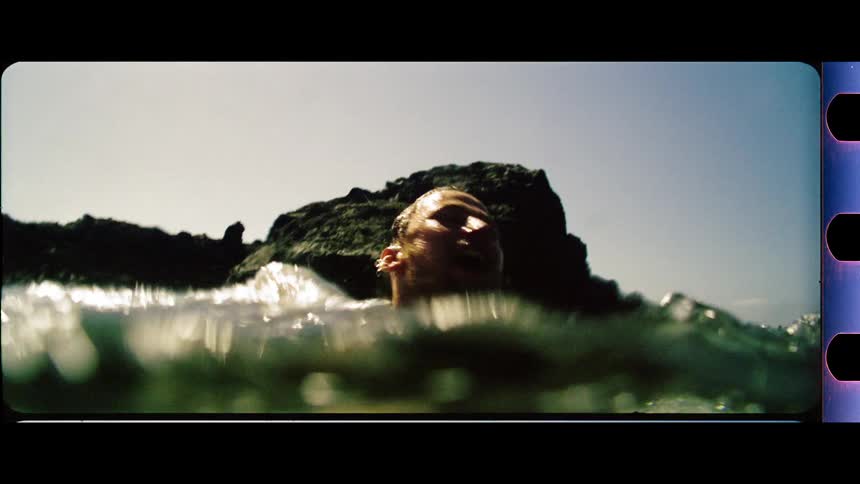 Man swimming in the ocean above and below the surface