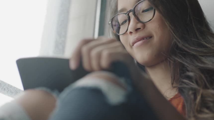 Woman wearing glasses writing in journal